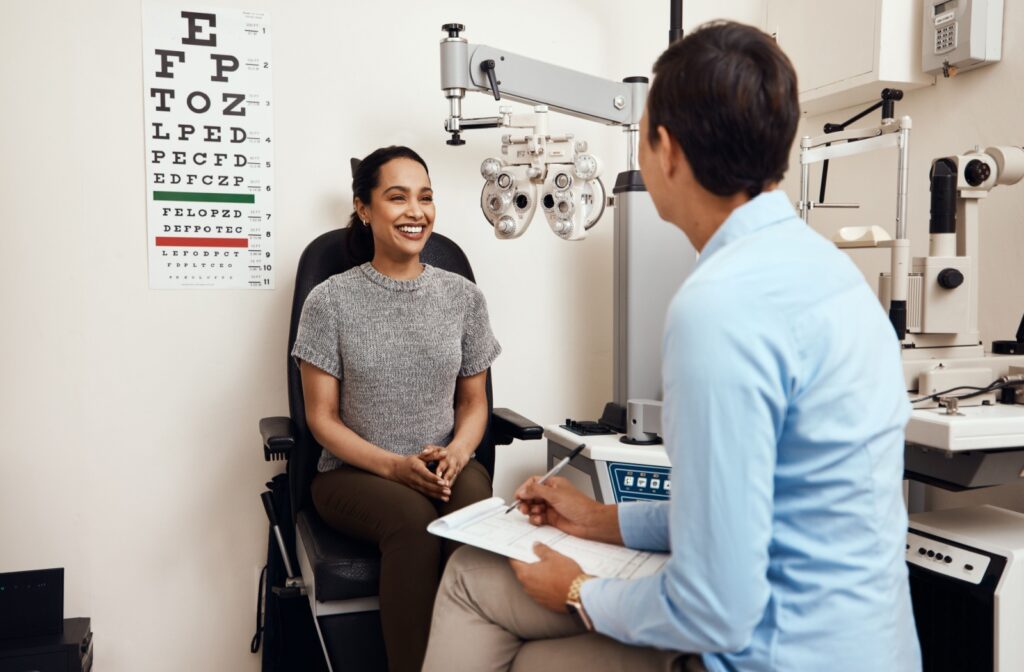 A person smiling during an eye exam consultation with an eye care professional.