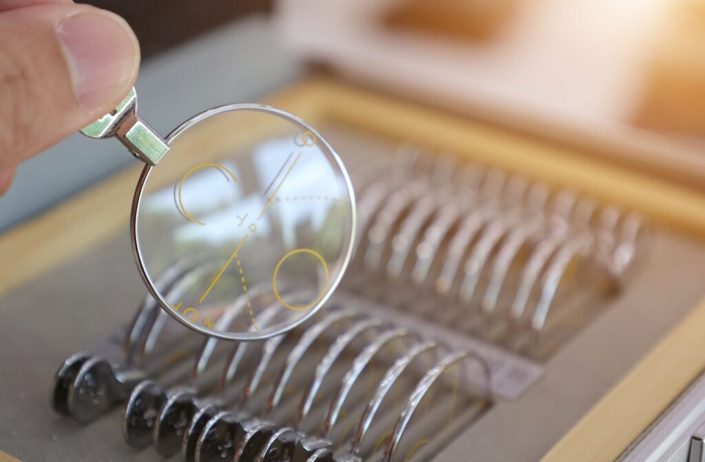 A row of eyeglass lens samples, with one pulled out showing the progressive lens zones