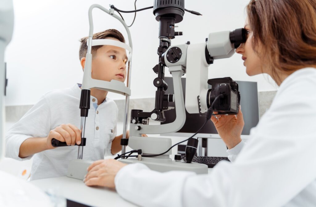 A child at an eye exam having their eyes tested by an optometrist for refractive errors like astigmatism.