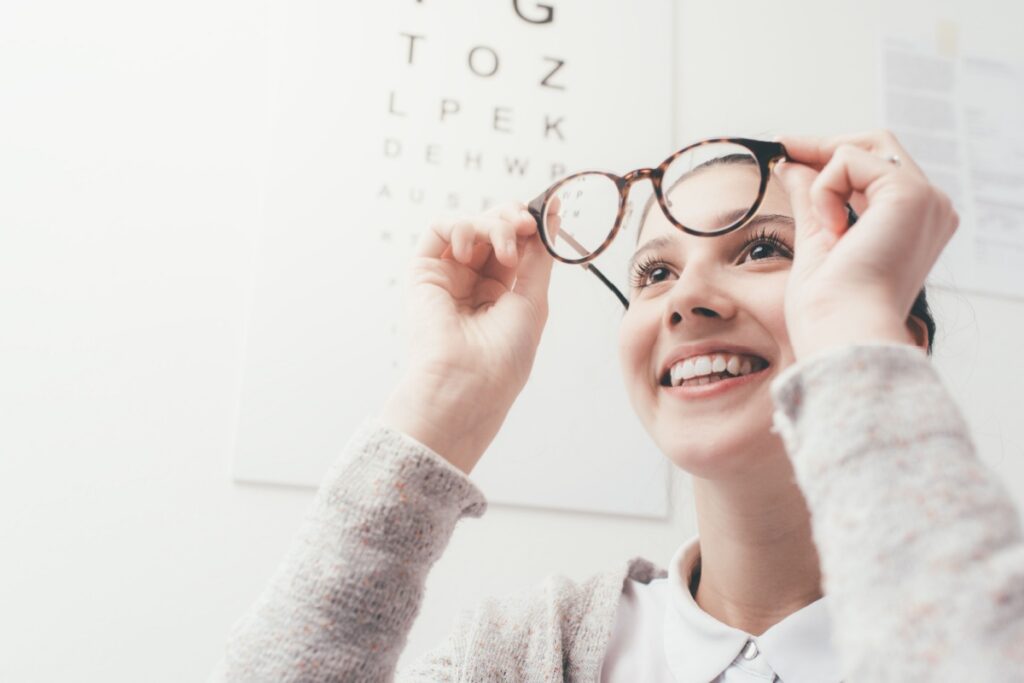 A young child looking through a pair of glasses to help correct their myopia.